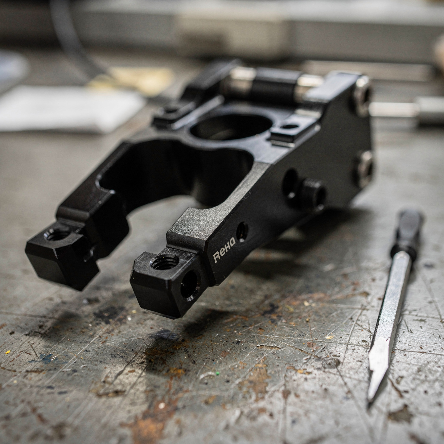 Black anodized aluminum robotic gripper end-effector component on a workbench